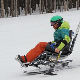 Funksjonshemmet mann kjører ski i skibakke