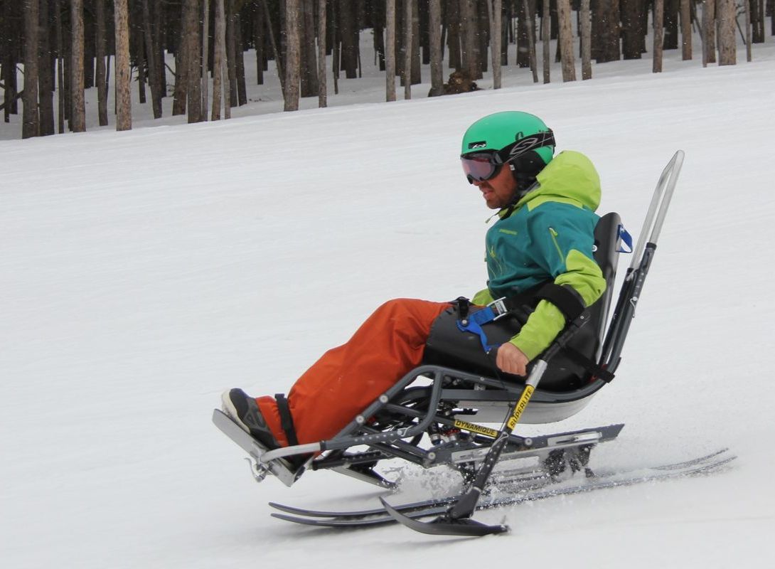 Funksjonshemmet mann kjører ski i skibakke